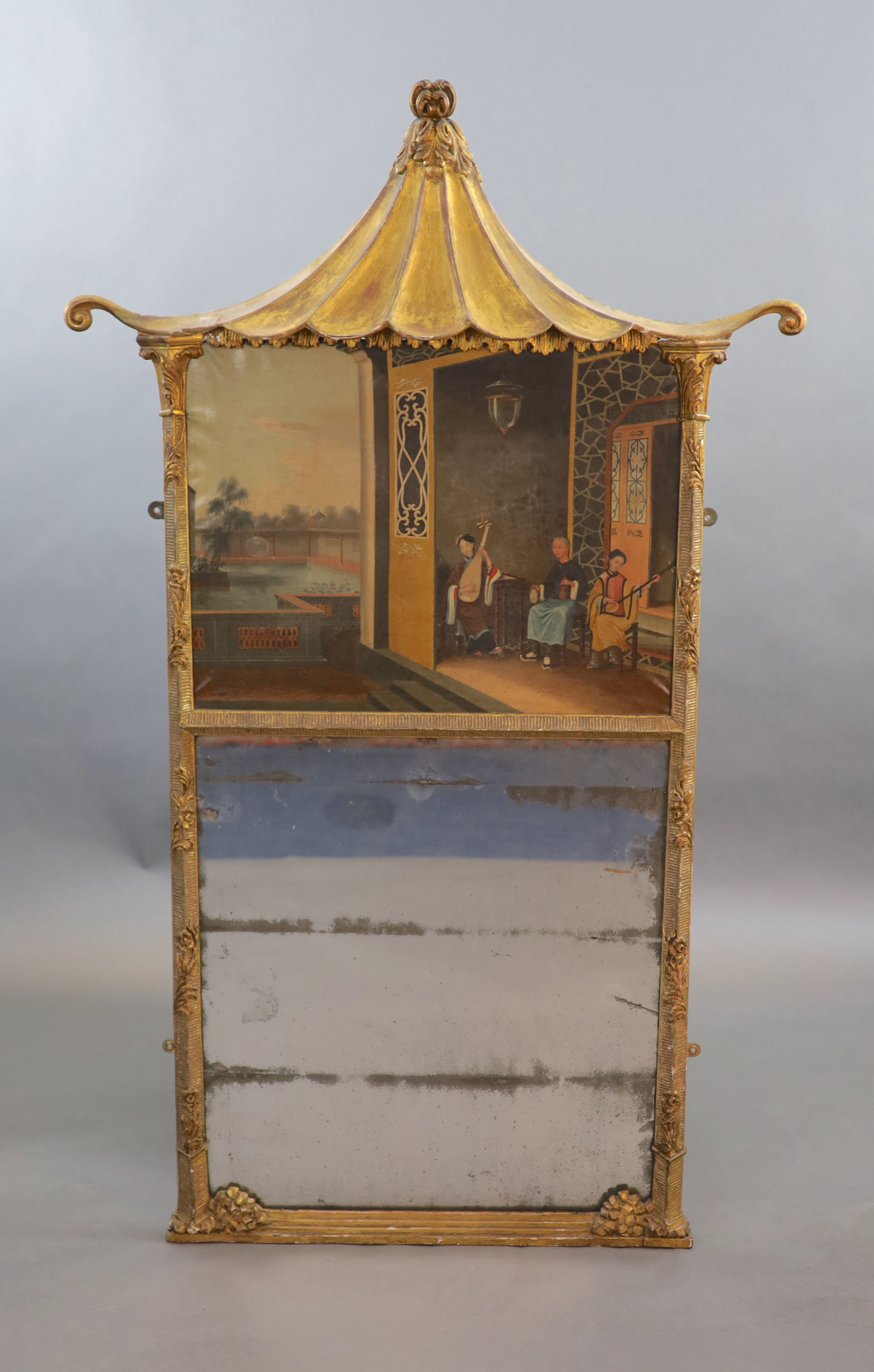 A mid 19th century giltwood and gesso wall mirror inset with a Chinese oil on canvas of musicians within a pagoda, in the manner of Tinqua H.147 cm W.88cm.
